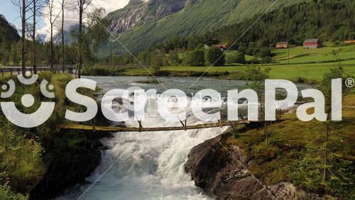 Suspension Bridge Over The Mountain River. Beautiful Nature Norway Natural Landscape.